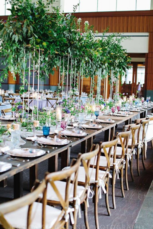 X back chairs lined up beside a table setting outside