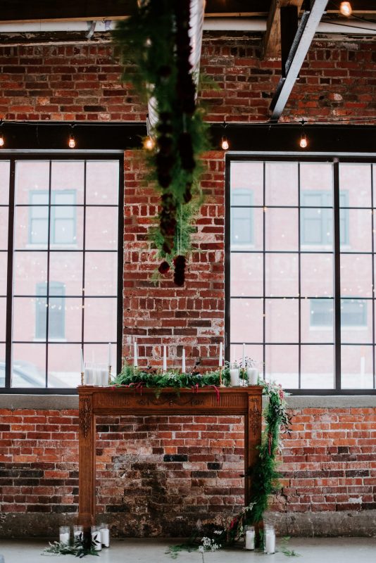 wooden fireplace wedding alter decorated with flowers and candles