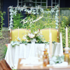 Our olive upholstered arm chairs used at a sweetheart table in an outdoor reception