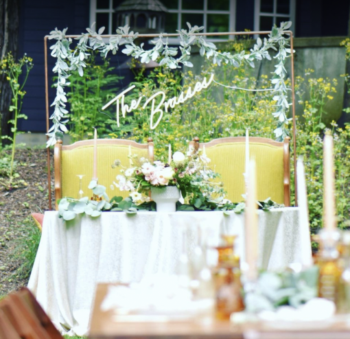 Our olive upholstered arm chairs used at a sweetheart table in an outdoor reception