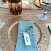 Gold charger with a blue napkin and light blue goblet