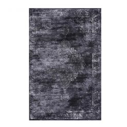 Dark gray area rug with a distressed medallion in white in the middle