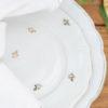 Close up on mismatched white plates with gold decoration. Dinner plate with salad plate on top. White napkin