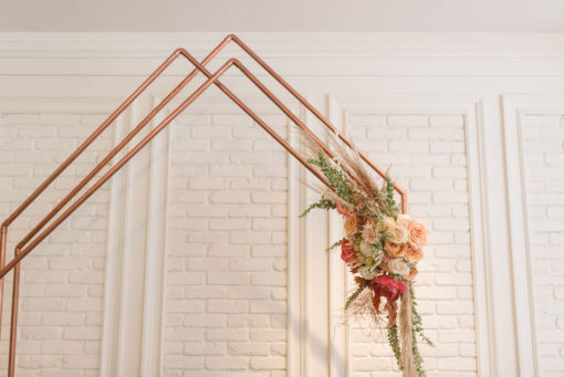 Close up on Colleen Copper Arch top as used in a wedding ceremony. Autumn shades of florals on the right side.