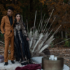 Moody photoshoot with a diverse couple standing on rugs with a gold coffee table and a dramatic backdrop.