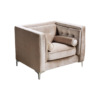 Beige velvet boxy chair with buttons on the back and inside on the sides. Silver legs. Small round pillows on sides.