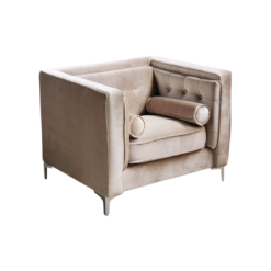 Beige velvet boxy chair with buttons on the back and inside on the sides. Silver legs. Small round pillows on sides.