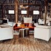 Burnt orange sofa with two boxy arm chairs on wooden floor at a barn.