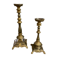 Giant gold candlesticks in various sizes. Thick base with legs, ornate stick and wide top to hold a pillar candle.