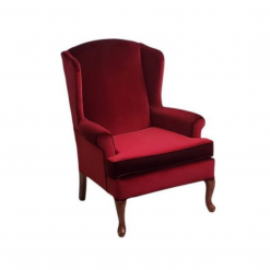 Deep red velvet arm chair with curved top and curved wooden legs.