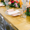 Tablescape with clear dinner plates, light blue goblets, orange candles with clear glass candlesticks.