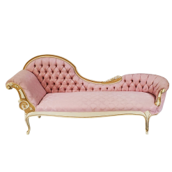 fainting sofa rental in a light pink fabric. High wave on the left flowing into a lower edge on the right. Left side has an arm for resting on. Tufted back and gold detailing.