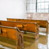 Pews in a row for an indoor wedding ceremony.