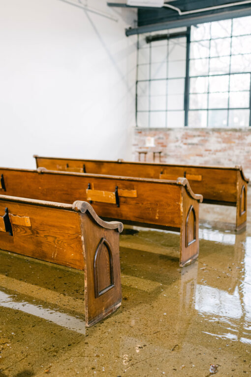 Pews in a row for an indoor wedding ceremony.