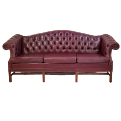 Maroon chesterfield sofa, front view. Button tufted back, wing arms, and 3 cushions.