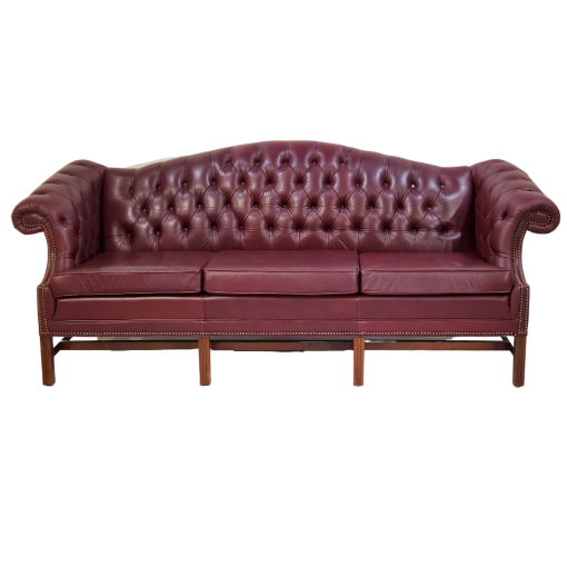 Maroon chesterfield sofa, front view. Button tufted back, wing arms, and 3 cushions.