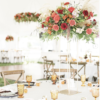 Outdoor wedding inside a tent. Round table at the reception with x-back chairs and tall florals in the center of the table. Amber mismatched goblets bring a pop of color.