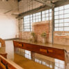 Church pews on shiny concrete floors in an industrial venue with windows and exposed brick.