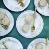 Vintage mismatched china plates with dessert and gold forks.
