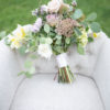 Soft gray barrel accent chair with bridal bouquet