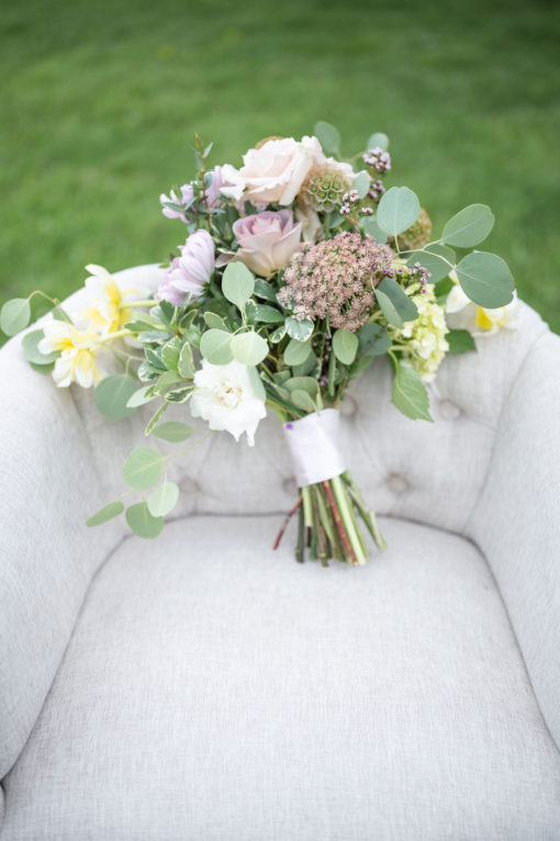 Soft gray barrel accent chair with bridal bouquet