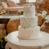 Off white circular vintage table as a cake display at a wedding reception table