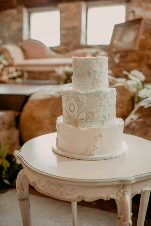 Off white circular vintage table as a cake display at a wedding reception table