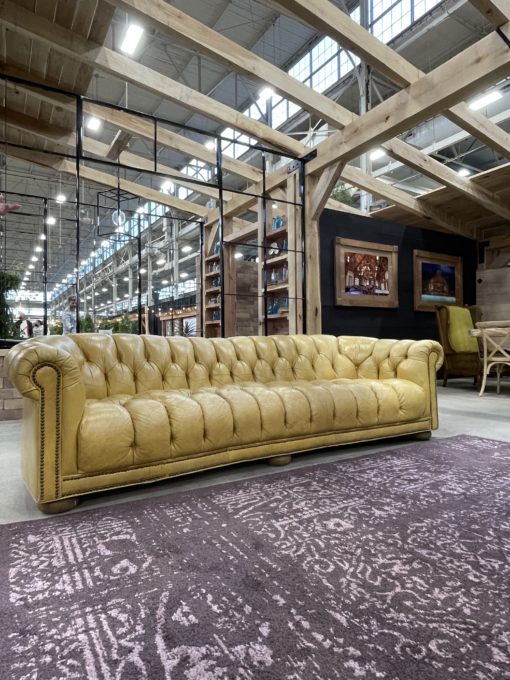 Yellow vintage leather chair with a purple area rug at an expo event