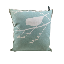 Sea-green pillow with a siloette of a bird on a bare branch in white.