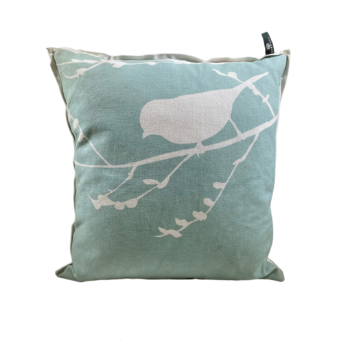 Sea-green pillow with a siloette of a bird on a bare branch in white.