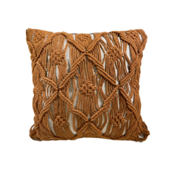Square off white pillow with burnt orange / rust colored macrame in designs over the pillow.