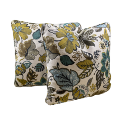 White square pillow with big bold florals and leaves in olive, green, light blue, and brown
