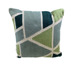 Pillow with geometric shapes in green, light blue, dark blue with white lines between shapes