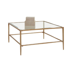 Large square coffee table with muted gold edges, legs and a glass top.
