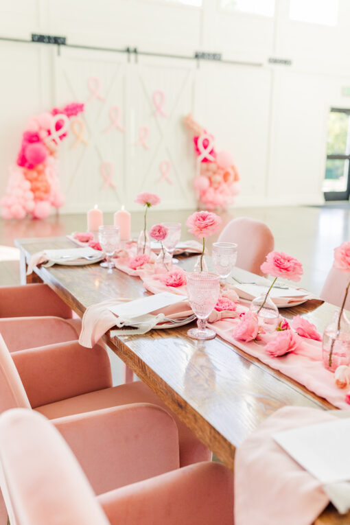 Pink velvet armchairs for breast cancer awareness at a dinner party table