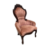 Victorian arm chair with pink velet, channel tufted back, dark wood ornate trim and rolled arms.