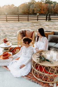 Boho chair rental guide a couple posing sitted outside within a boho decor setting
