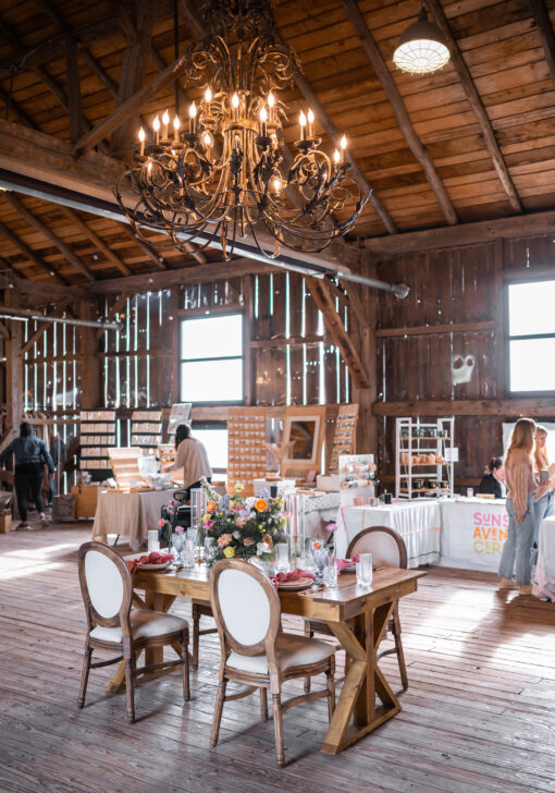 Wooden farm table with 4 french Louis chairs at a quaint barn setting.