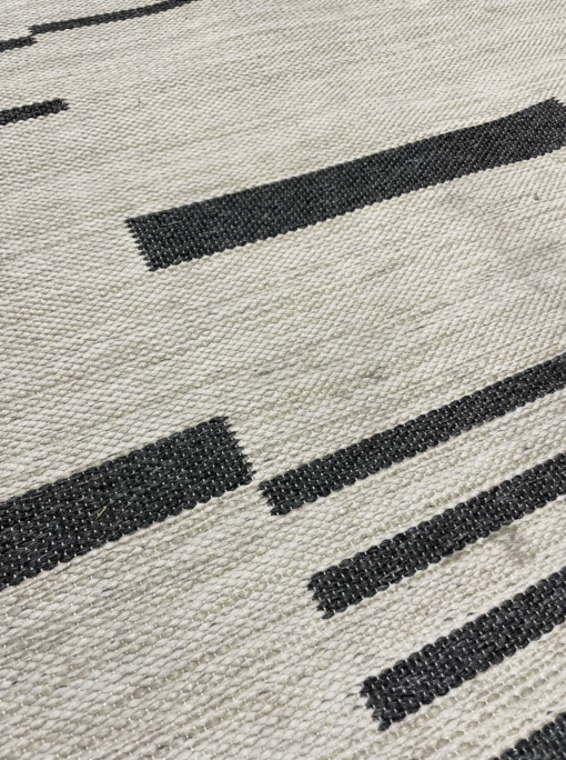Close up on the dark gray bars woven into the rug.