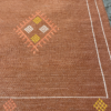 Close up of the white line border on the rug. Orange and yellow diamonds around the edge.