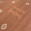 Rust colored rug with orange and white geometric designs