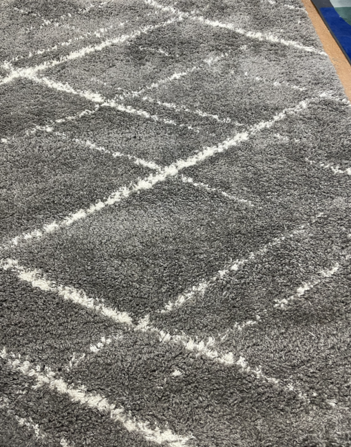 View of the gray rug with white lines making geometric overlapping diamonds.