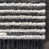 Gray and beige alternating stripes from rug with gray tassle fringe.